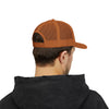 Person wearing a brown trucker cap and black hoodie on a white background