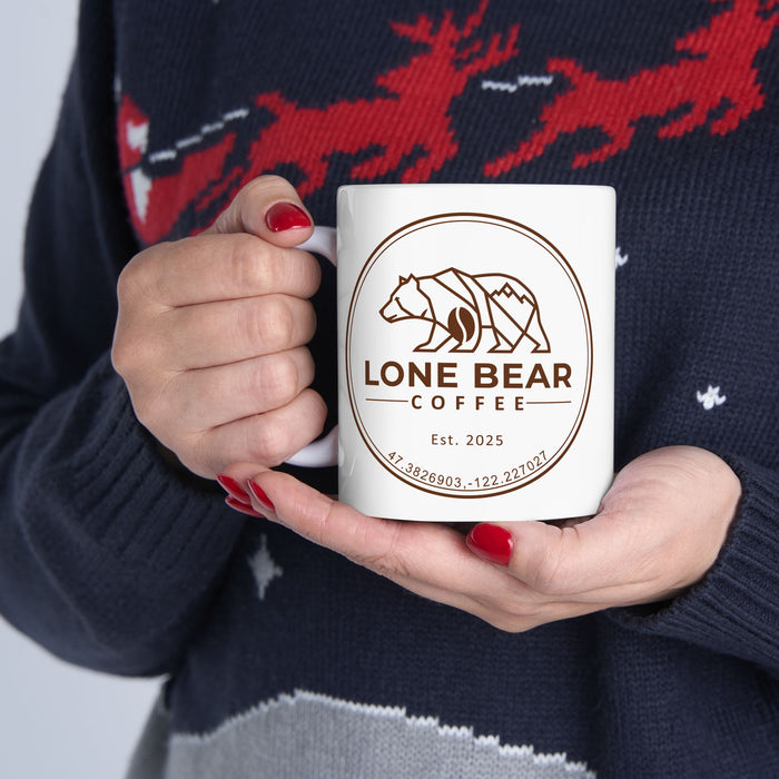 Person holding a white ceramic mug with Lone Bear Coffee logo